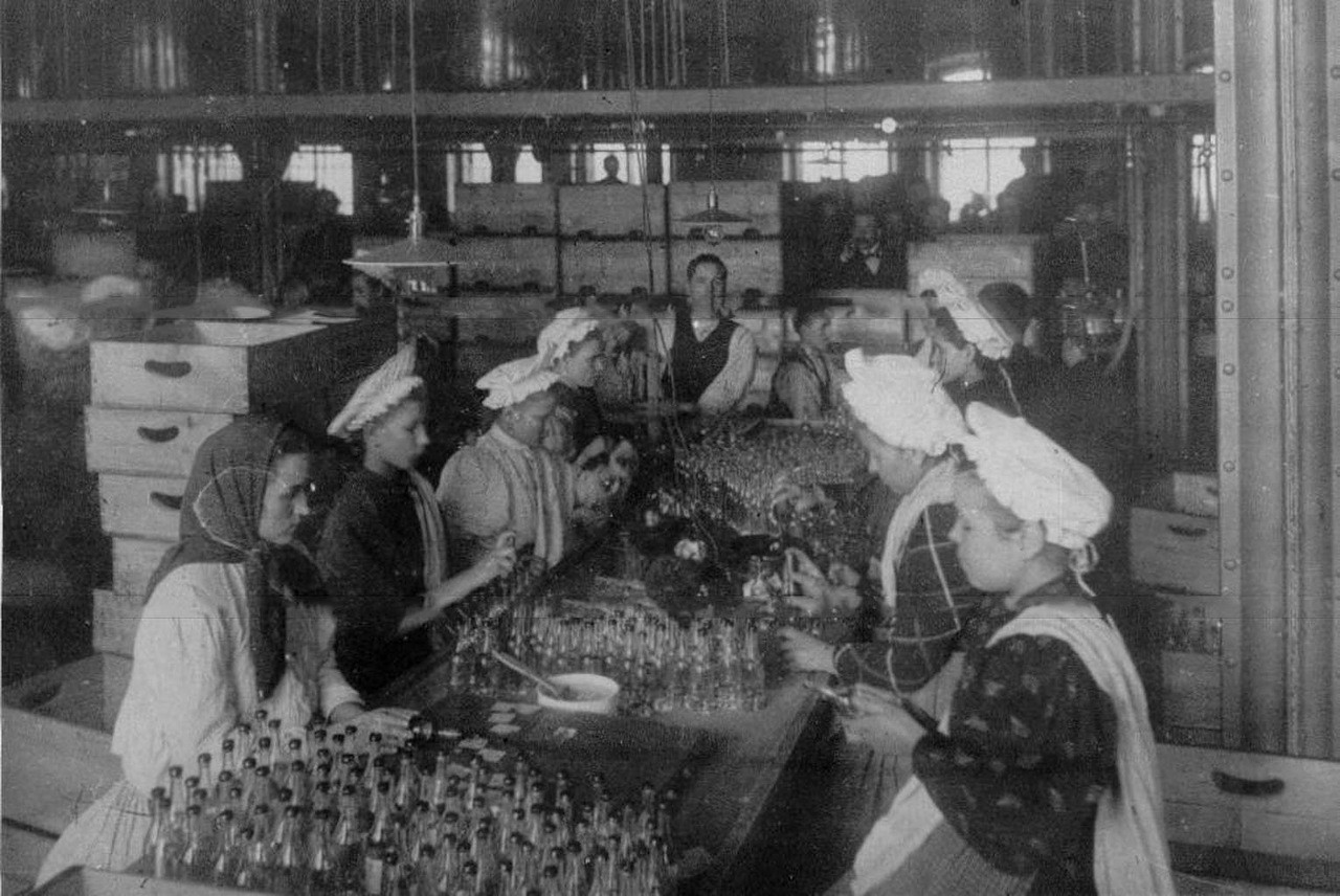 Mujeres etiquetando botellas antes de enviarlas al mercado.