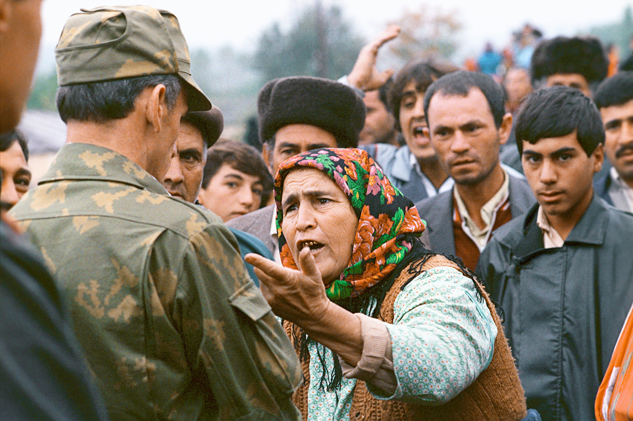 ナゴルノ・カラバフの年寄りの女性が軍人と話している。