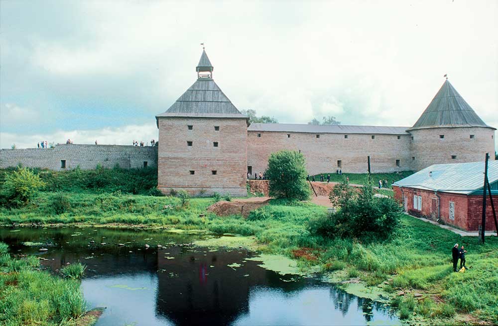 Staraya Ladoga Fortress. West wall with Vorotnaya Tower (left) & Clement Tower. Foreground: Ladozhka River. August 16, 2003.