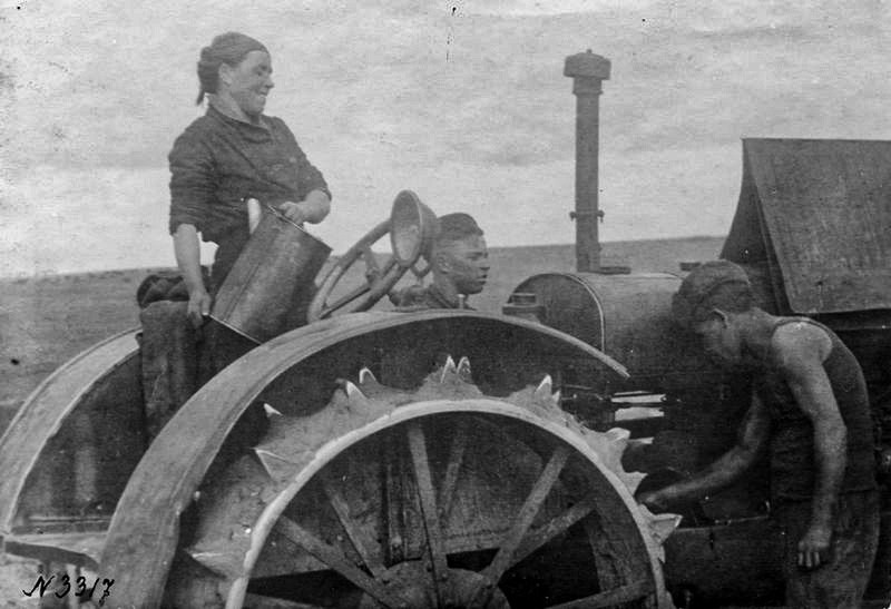 Une tractoriste travaille dans un village