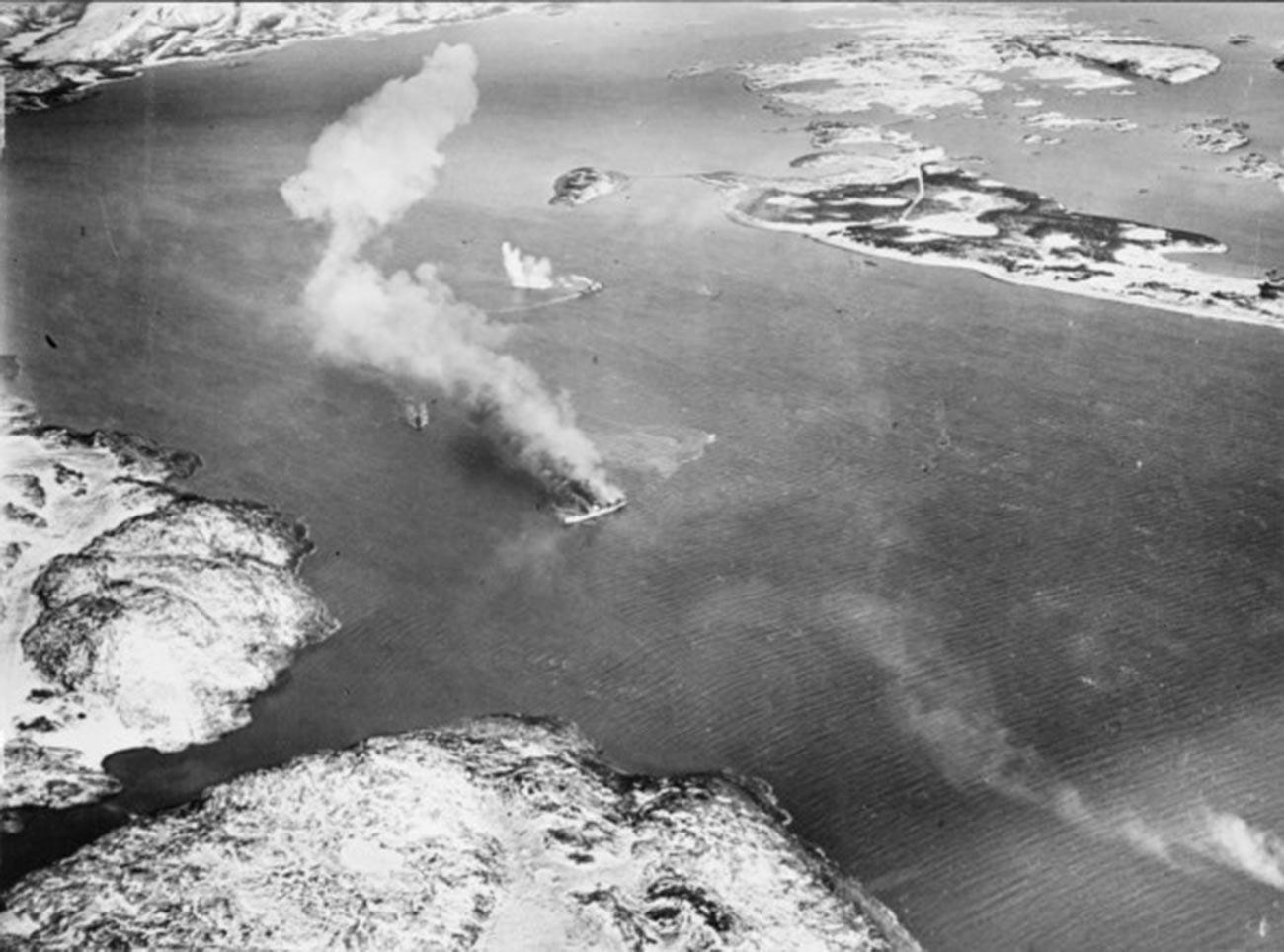 The German-controlled prisoner ship Rigel and a small V-boat escort burning after being bombed and strafed by British aircraft.