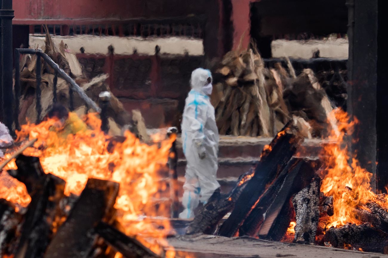 A man wearing PPE (Personal Protection Equipment) performs the last rites to his relative who died of the Covid-19 coronavirus disease at a crematorium on April 20, 2021 in New Delhi, India. 