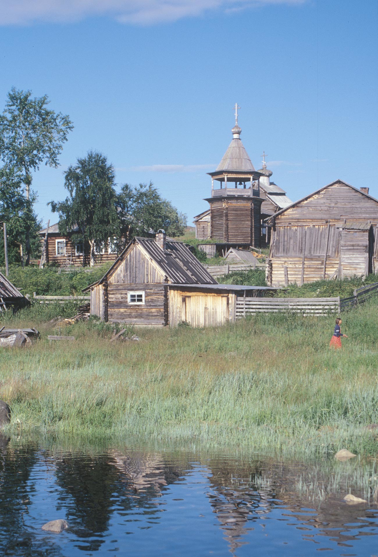 Kovda. Maison en rondins, banya et grange. Contexte: clocher et église Saint-Nicolas. Photographie: William Brumfield. 24 juillet 2001