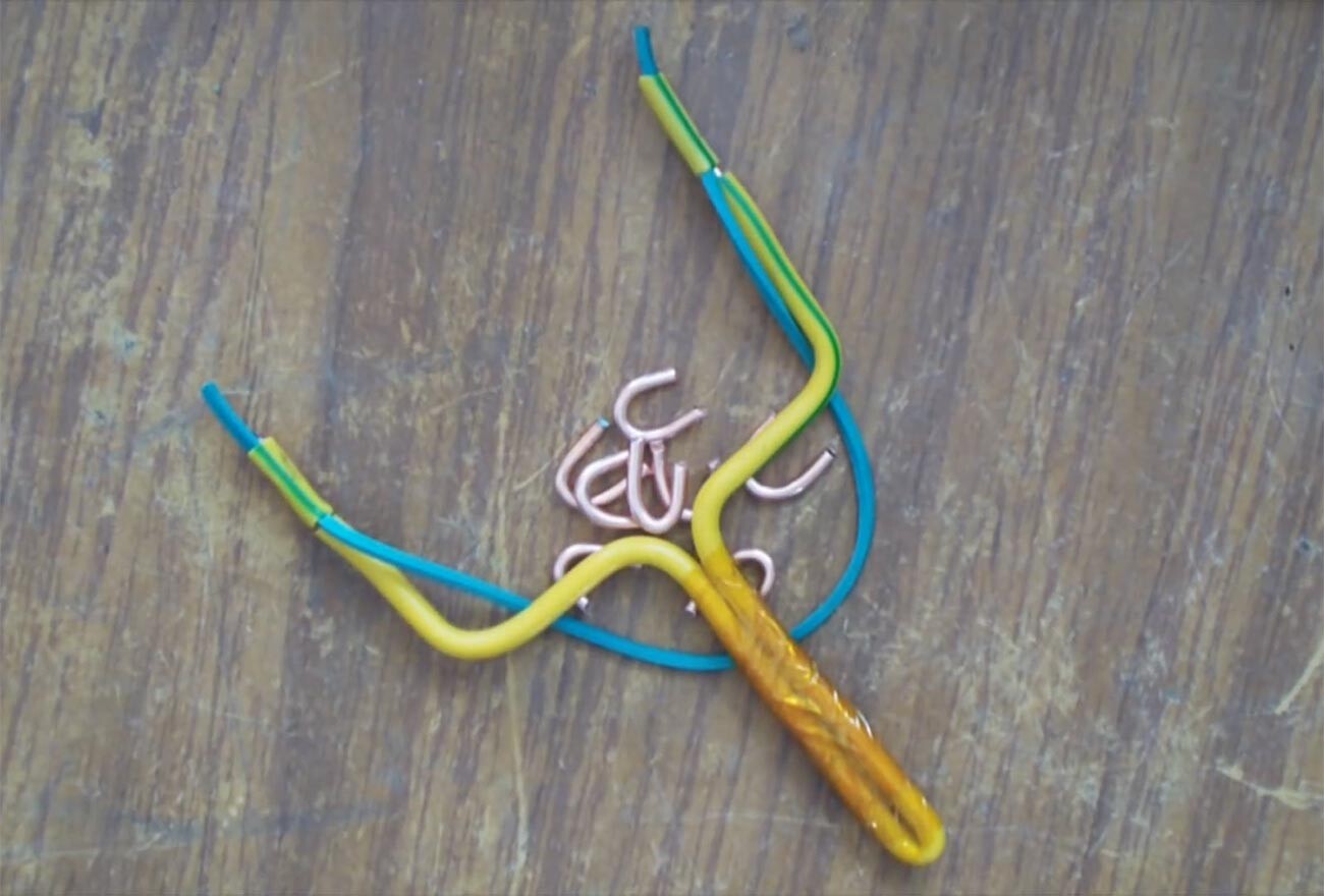 A pocket slingshot made from aluminum wire, and some U-shaped projectiles.