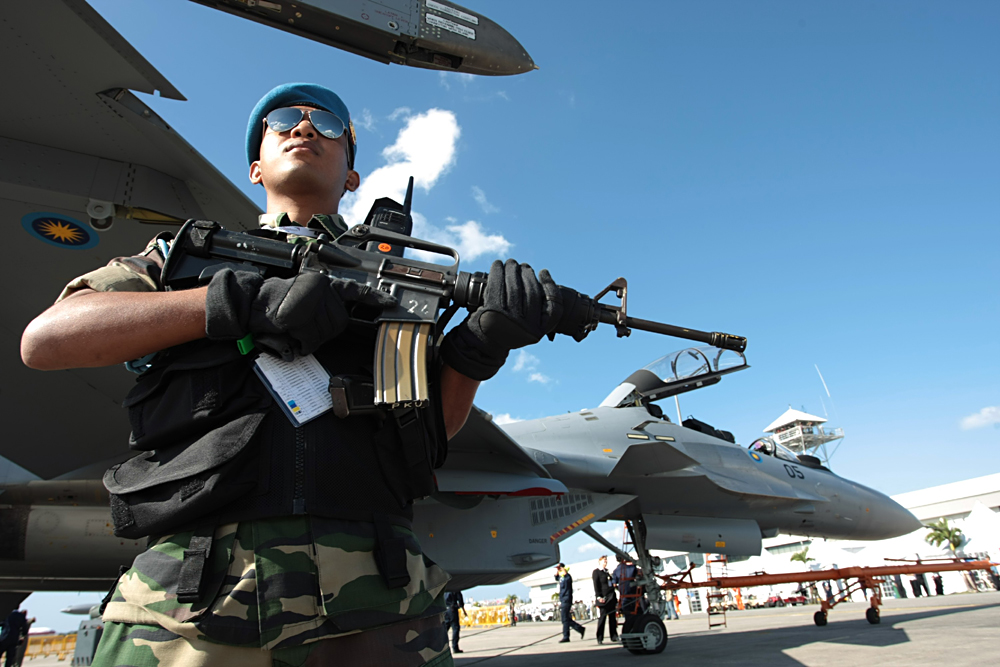 Malaysian soldier armed with rifle stands on guard near Royal Malaysian Air Force Sukhoi Su-30MKM jet fighters at the 2007 Langkawi International Maritime & Aerospace Exhibition (LIMA 2007) in Malaysia. Source: Marina Lystseva/TASS