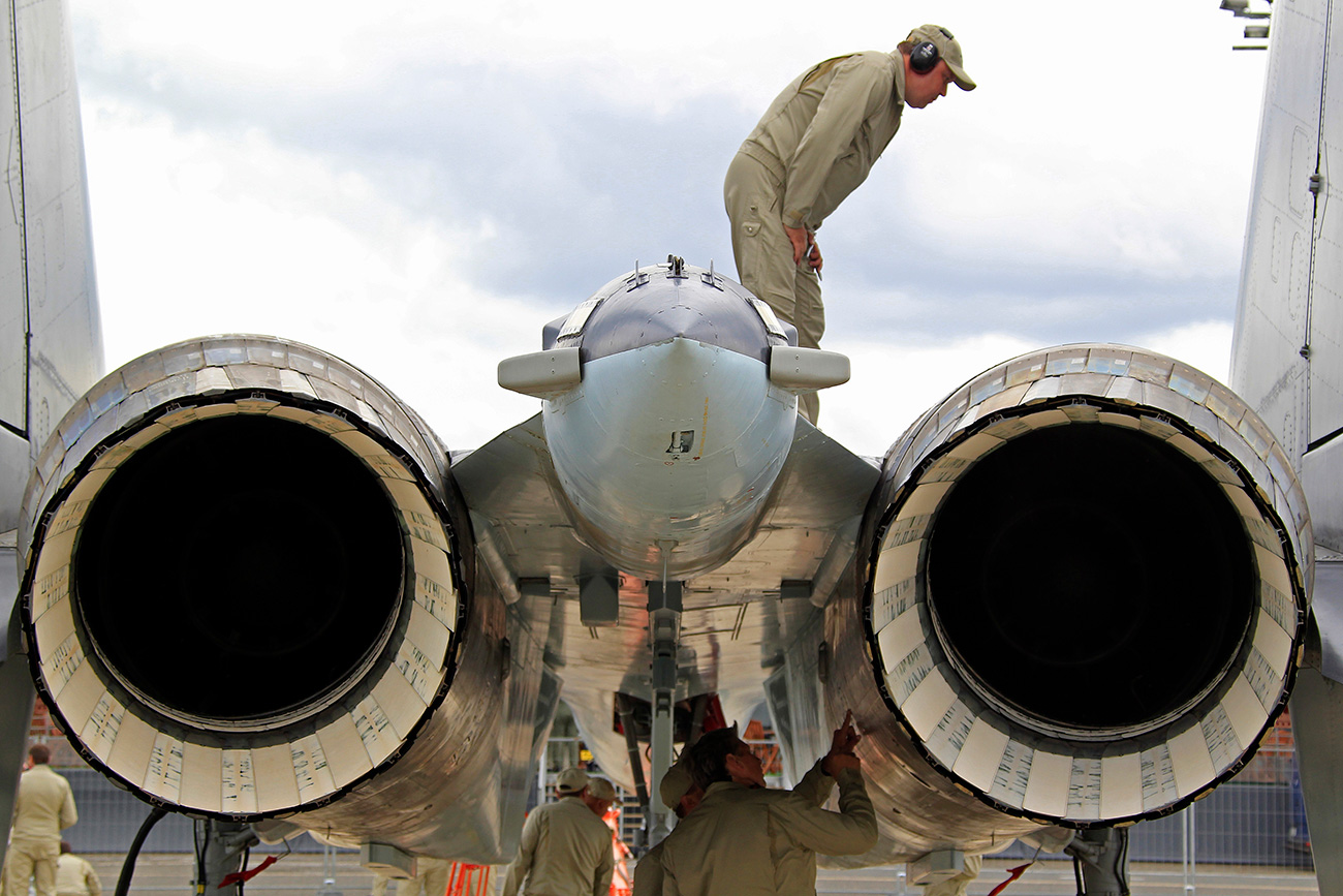 Engineers check specials vectored thrust jet engines of a Sukhoi Su-35 fighter after a flying display. / Photo: Reuters