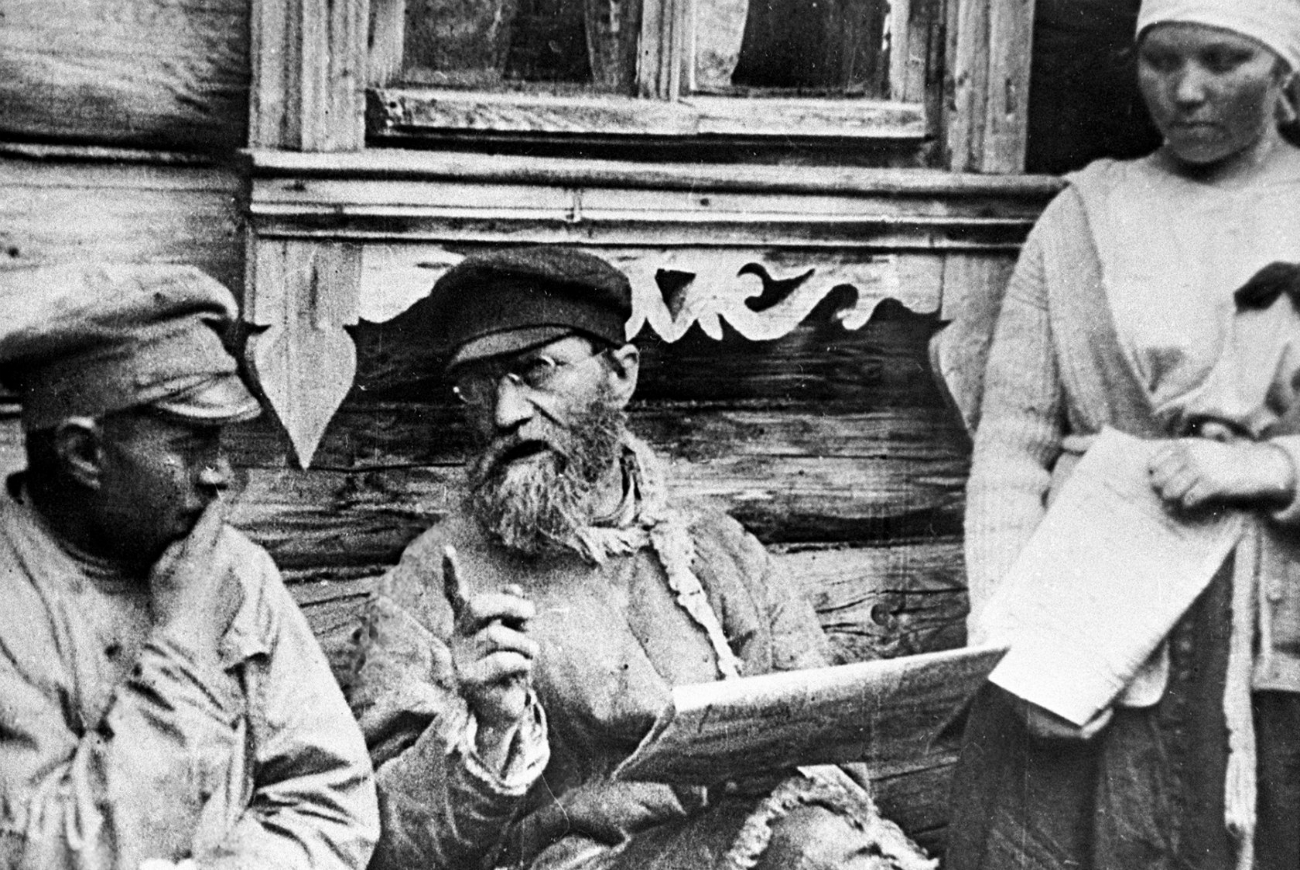 Para petani membaca sebuah surat kabar yang menerbitkan keputusan Lenin tentang tanah dan perdamaian, tahun 1918. Sumber: RIA Novosti