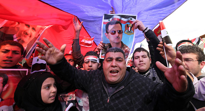 Para demonstran yang mendukung rezim pro-Suriah berunjuk rasa di bawah bendera Rusia dan gambar Presiden Bashar Assad di depan Kedutaan Besar Rusia di Beirut, Lebanon, 5 Februari 2012. Sumber: AP