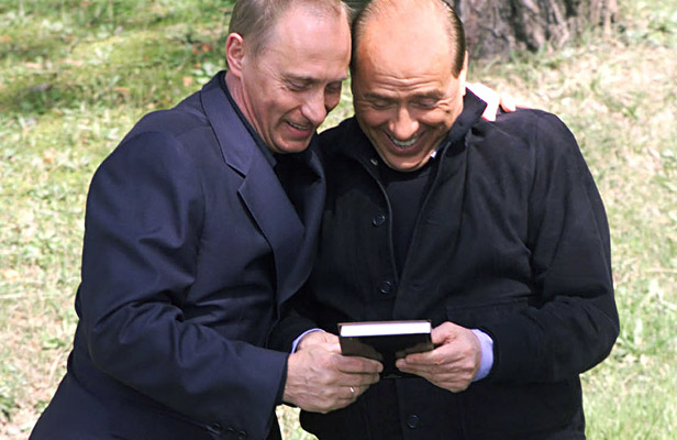 Ruski predsednik Vladimir Putin kaže italijanskemu premierju Silviu Berlusconiju knjigo Berlusconijev učinek, ki so jo izdali v Rusiji. Fotografija je bila posneta na neformalnem srečanju v rezidenci Bočarov Ručej v letovišču Soči ob Črnem morju. Vir: AP.