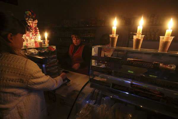 A customer visits a grocery lit with candles due to a power cut, in Simferopol, Crimea, November 22, 2015. Foto: Reuters 