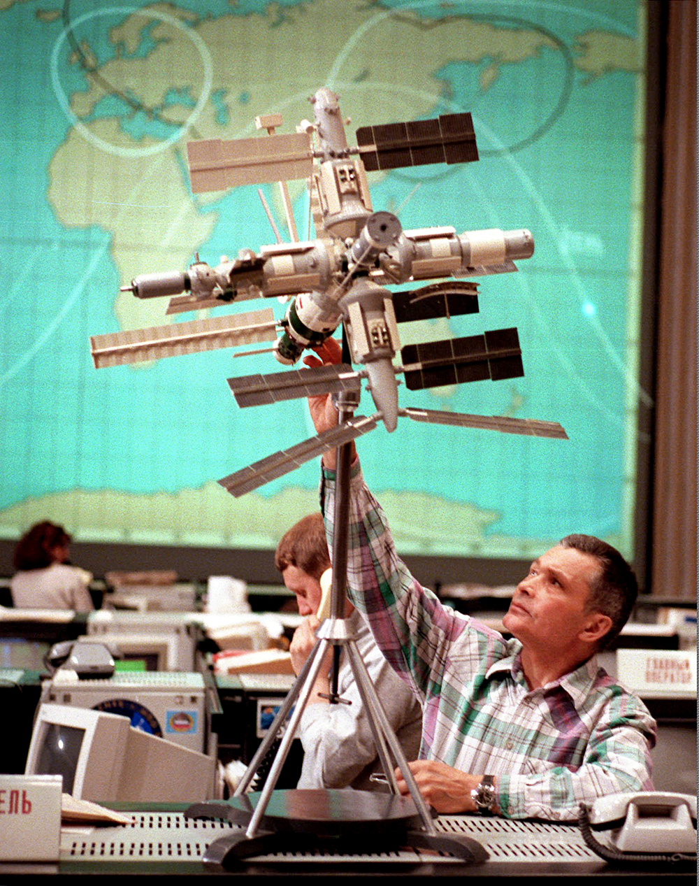  A flight controller adjusts a model of the Mir station at the Russian Mission Control center near Moscow, during a spacewalk performed by the Mir's two Russian cosmonauts, Wednesday, April 22, 1998. Cosmonauts Talgat Musabayev and Nikolai Budarin spent more than six hours in open space Wednesday to install a new orientation engine on the outside of the orbiter. Orientation engines keep the Mir pointed toward the sun, to allow the station's solar batteries soak up maximum energy. Foto: AP