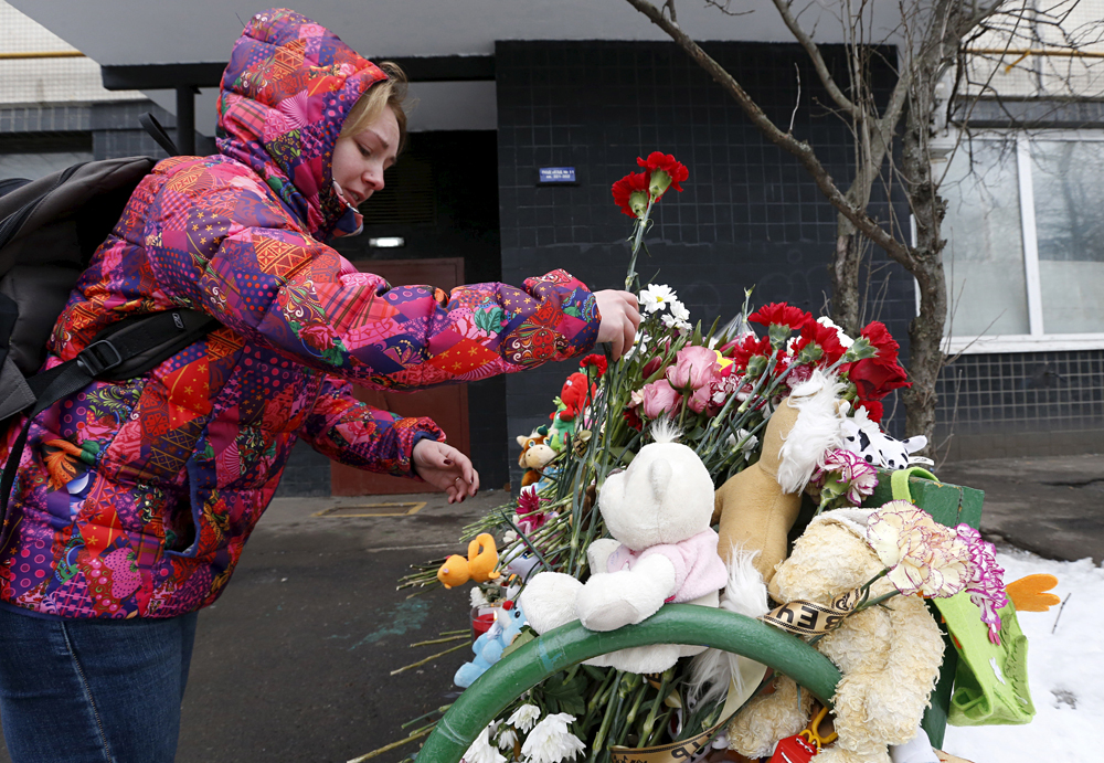 A woman brings flowers to commemorate the recently murdered child outside a residential building, where the child together with family members lived, in Moscow, Russia, March 1, 2016. Russian police wrestled to the ground a woman in a hijab brandishing the severed head of a child outside a Moscow metro station on Monday and charged her with murder, in an incident that stirred fears of an Islamist terrorist attack. Foto: Reuters