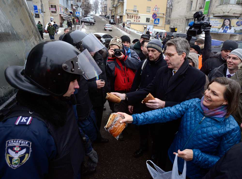 Victoria Nuland and Geoffrey Pyatt distribute bread to riot police near Independence square in Kiev December 11, 2013. Source: Reuters