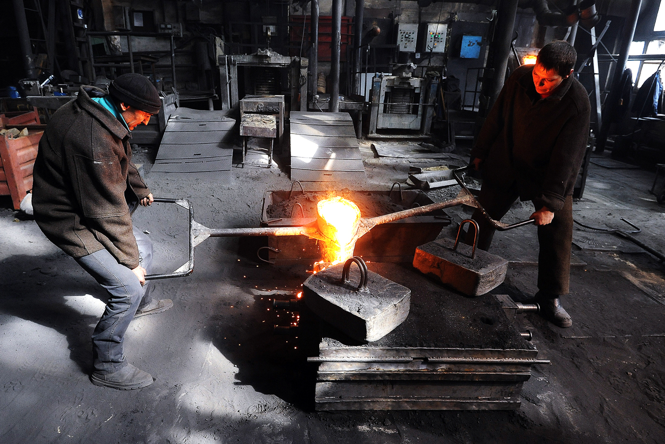 Worker of the Kasli Plant of Art Casting pour cast iron into foundry moulds. Source: Alexander Kondratuk / RIA Novosti