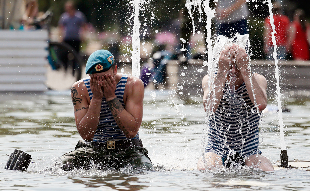 Former paratroopers splash themselves with water as they sit in a fountain during celebration of Paratroopers' Day in Moscow. Source: AP