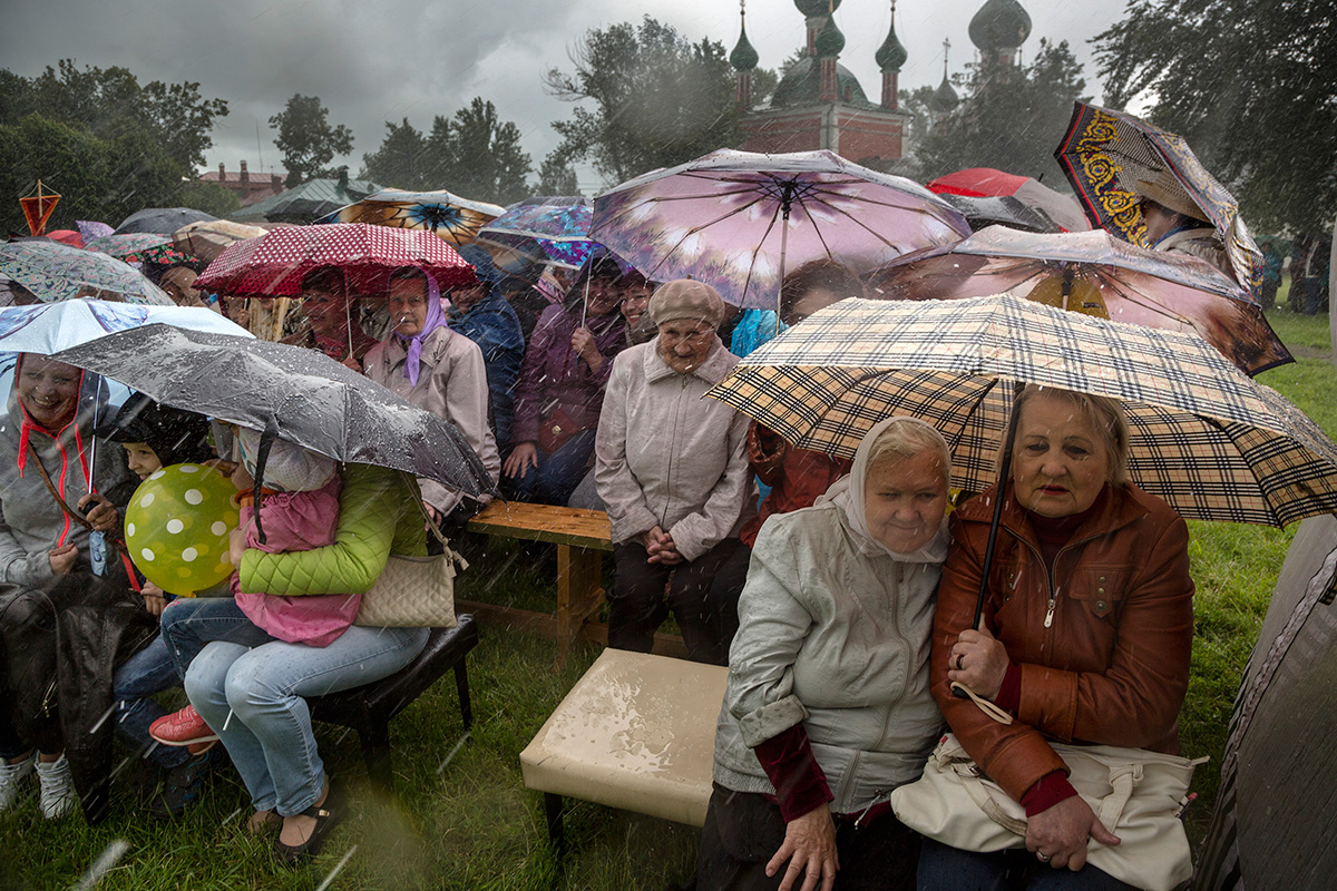 Mujeres acuden a una celebración un día de lluvia.