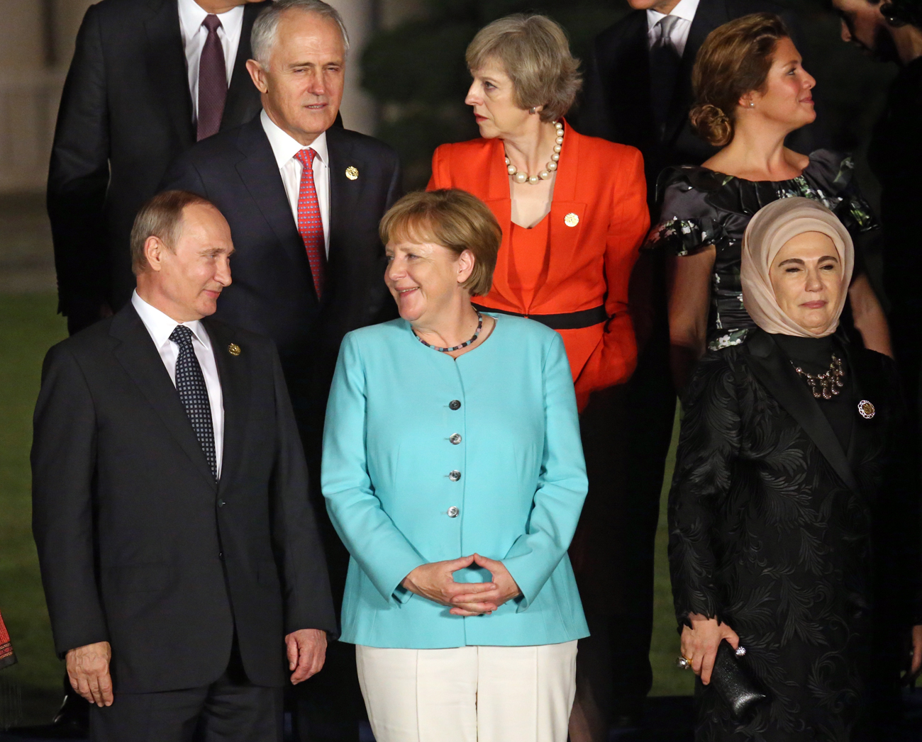 Russian President Vladimir Putin, left, speaks with German Chancellor Angela Merkel, center, while British Prime Minister Theresa May talks, center second row, during a group photo session for the G-20 Summit at Xizi Hotel in Hangzhou in eastern China's Zhejiang province / AP