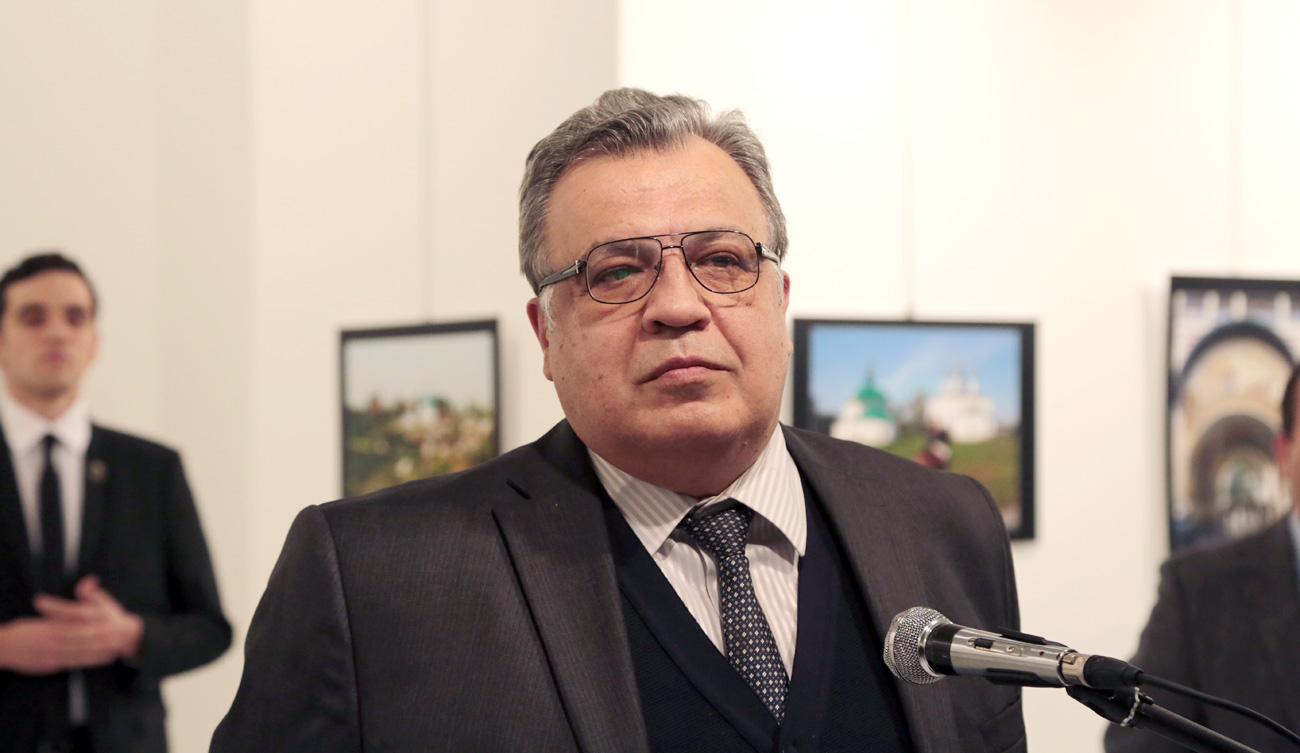 The Russian Ambassador to Turkey Andrei Karlov speaks a gallery in Ankara Monday Dec. 19, 2016. A gunman opened fire on Russia's ambassador to Turkey Karlov at a photo exhibition on Monday. The Russian foreign ministry spokeswoman said he was hospitalized with a gunshot wound. The gunman is seen at rear on the left.  Source: AP