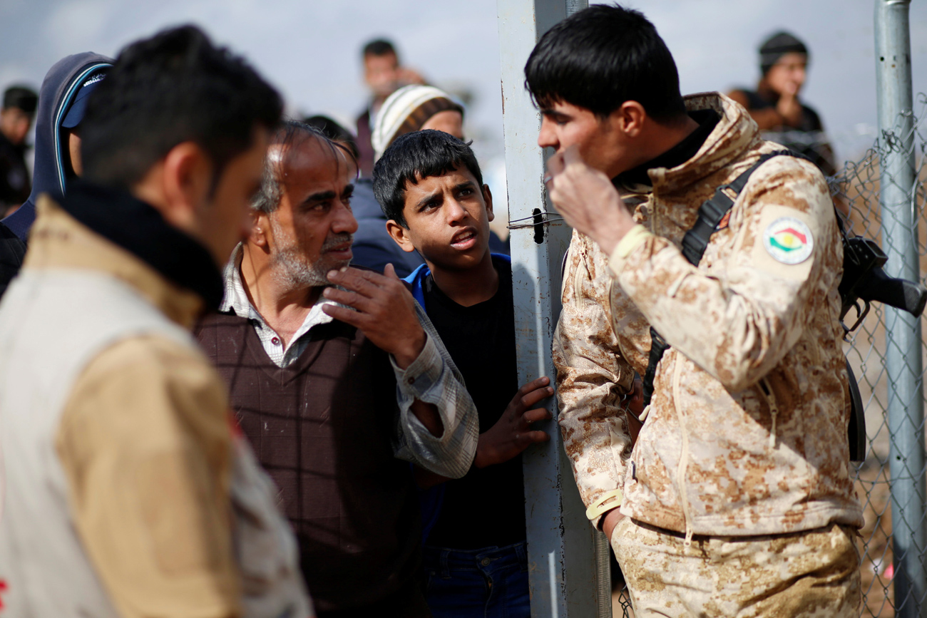 Displaced Iraqi people who fled from fighting Islamic State militants in Mosul, speak with the Peshmerga forces at Khazer camp, Iraq. Source: Reuters