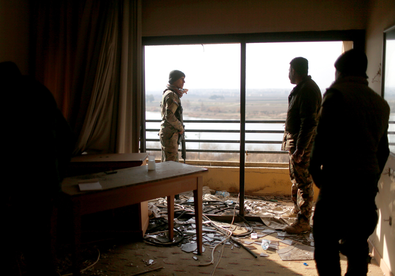 Iraqi soldiers look out from a damaged room in the five-star Ninewah Oberoi Hotel in Mosul city, Mosul, Iraq. Source: Reuters