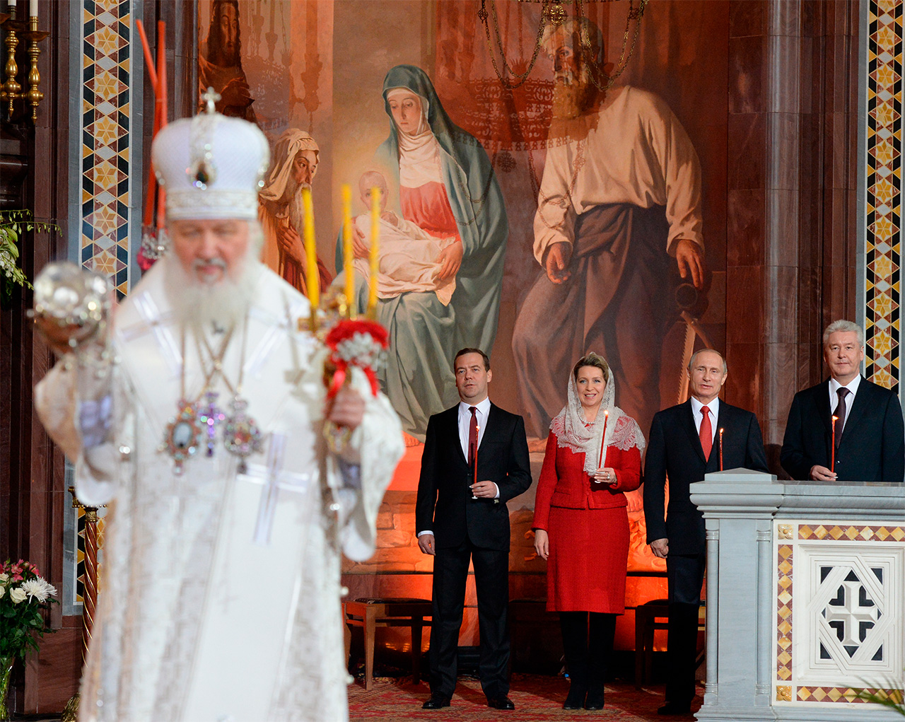 Der Patriarch von Moskau und der ganzen Rus Kyrill (vorn) sowie der russische Ministerpräsident Dmitrij Medwedjew mit dessen Frau, dem russischen Präsidenten Wladimir Putin und dem Moskauer Bürgermeister Sergej Sobjanin während der Ostermesse im April 2015 in der Christi-Erlöser-Kathedrale in Moskau (v.l.n.r.). Sergey Pyatakov/RIA Novosti