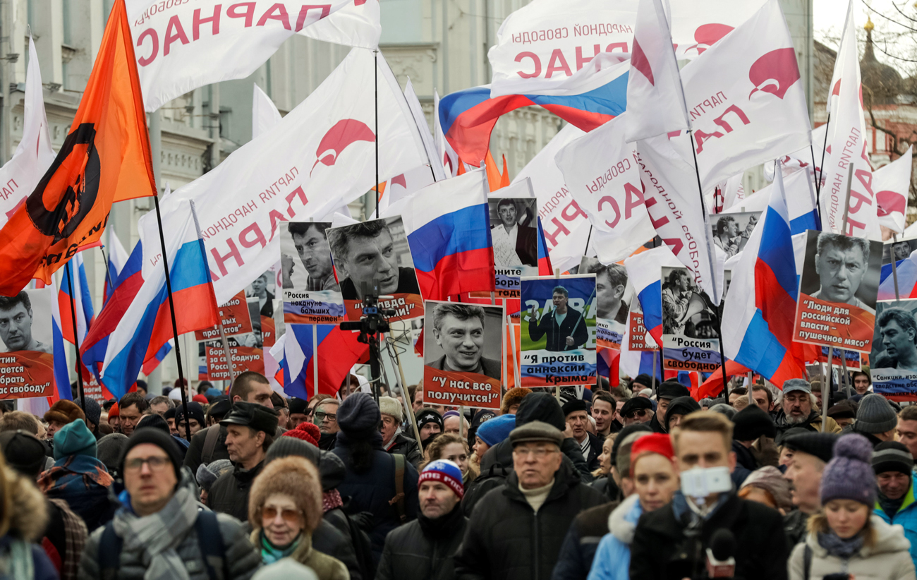 Opposition supporters hold portraits of Kremlin critic Boris Nemtsov. Source: Reuters