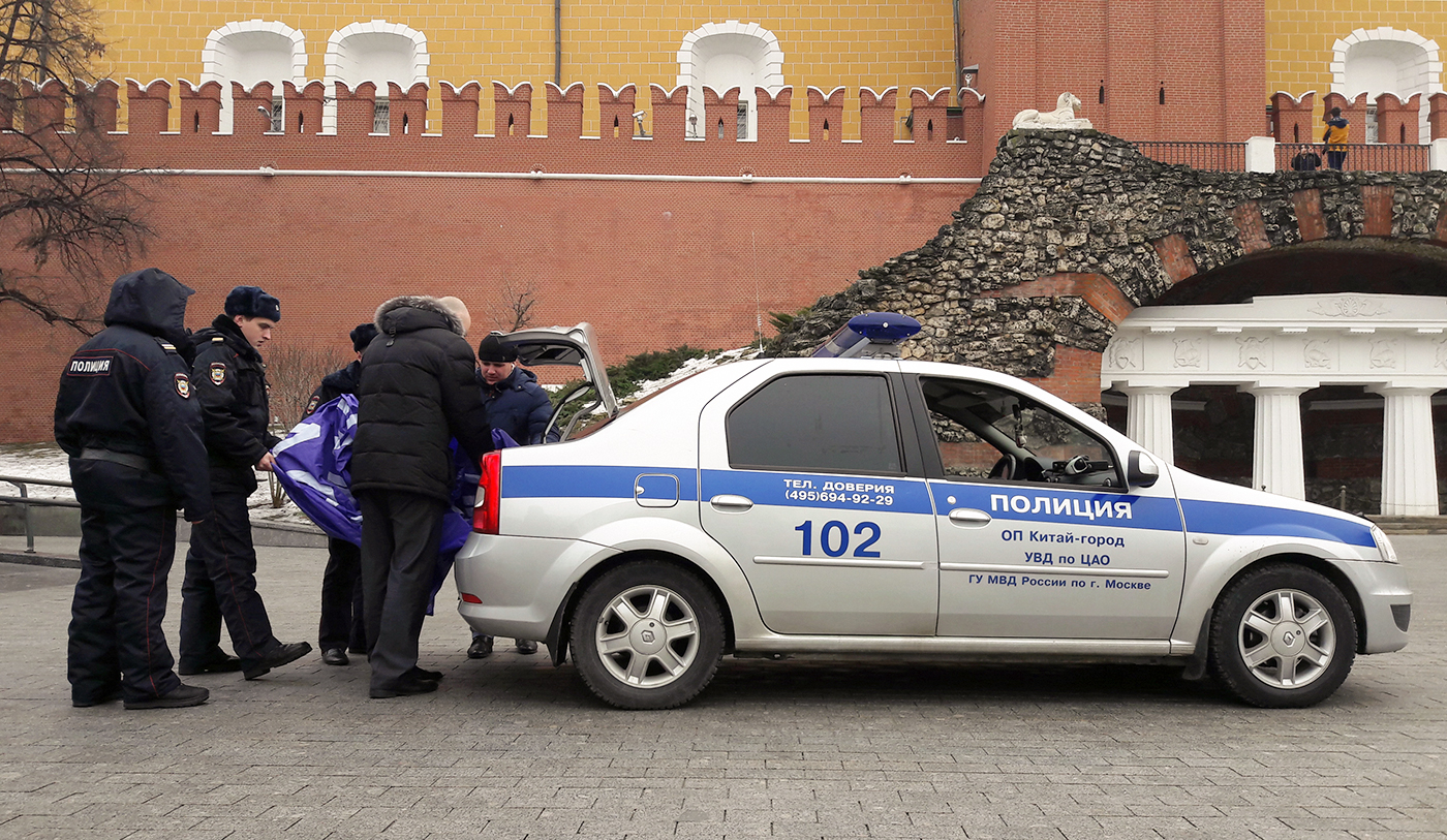 Police officers detain feminist activists who unfurled a banner and lit smoke flares outside the Kremlin on the International Women's Day. / Photo: TASS