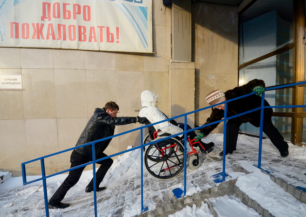 Eine Teilnehmerin des Wettbewerbs „Schönheit ohne Grenzen“ für Frauen im Rollstuhl in Wladiwostok erhält Hilfe.  / Reuters