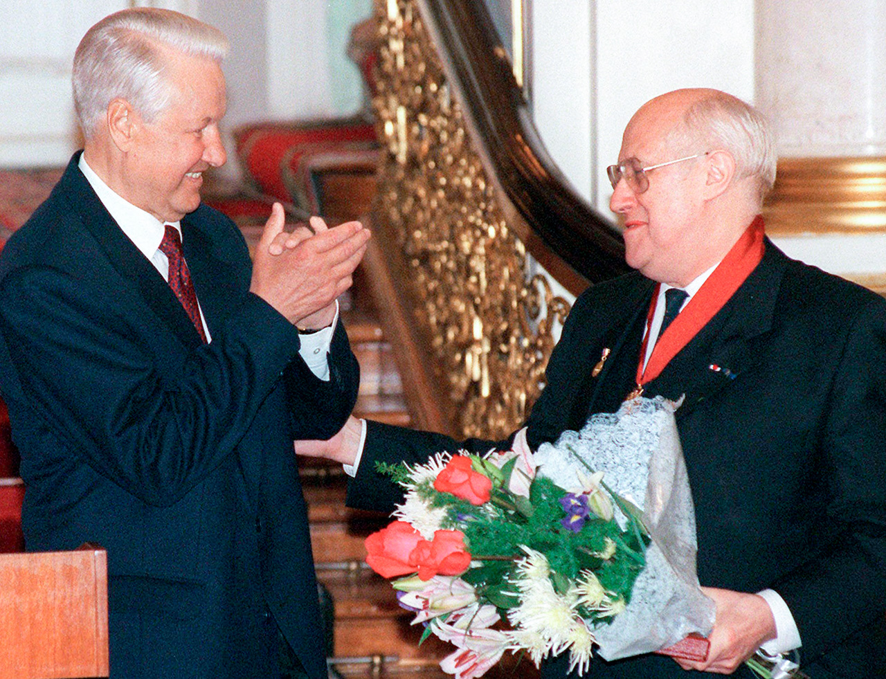 Mstislav Rostropovich holds flowers while President Boris Yeltsin applauds after he honored Rostropovich with Russia's award for "Services Rendered to the Fatherland," at a ceremony in Moscow's Kremlin in 1997.