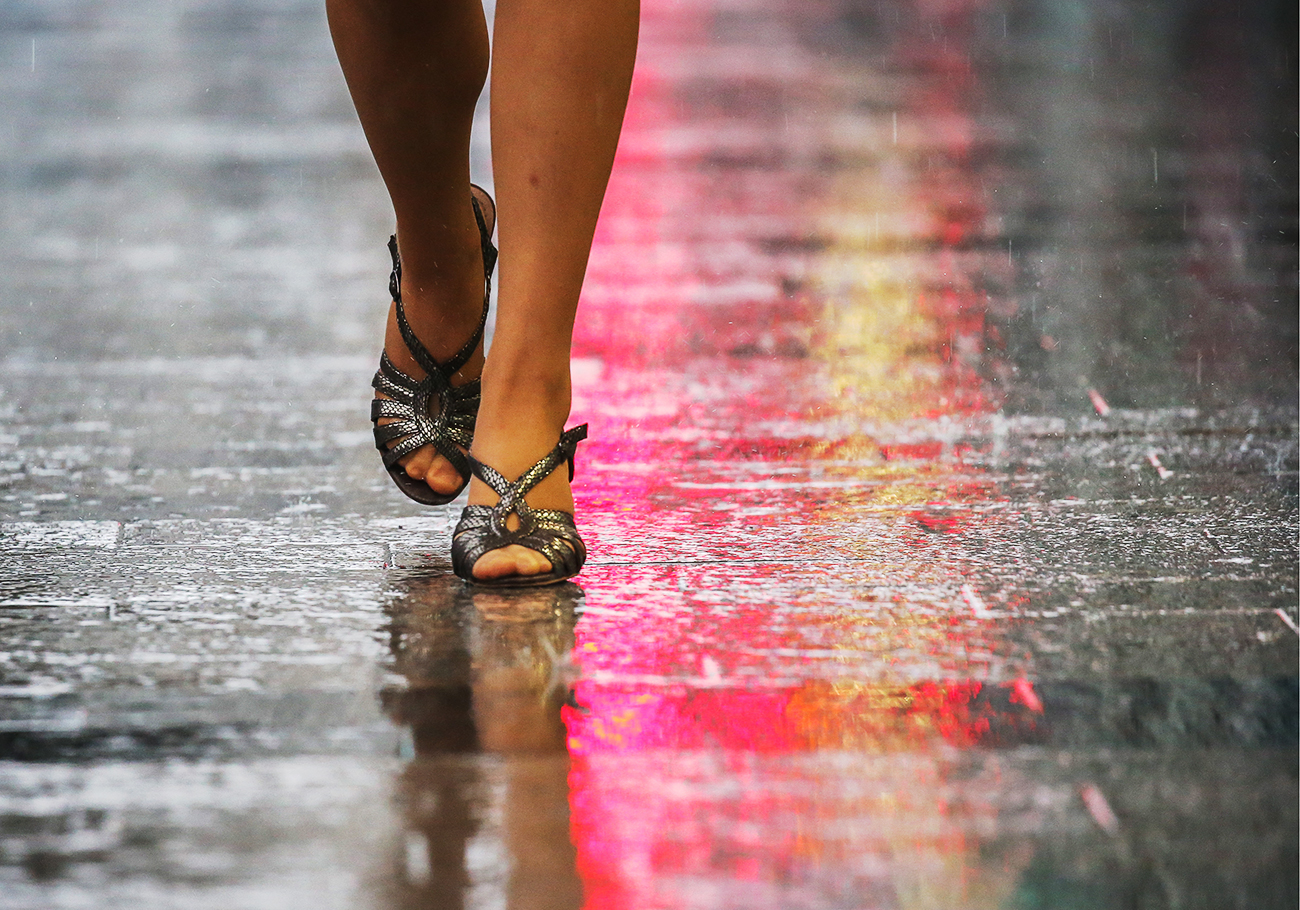 Ragazza cammina sotto la pioggia in una strada di Mosca. Fonte: Artyom Geodakyan/TASS