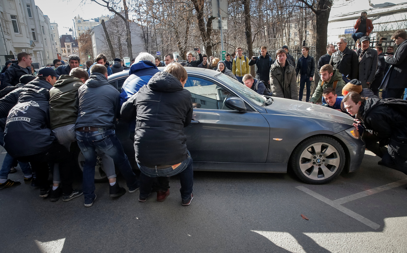 Protestniki so na cesto premaknili avtomobil, da bi blokirali kombi s pridržanim politikom Aleksejem Navalnim, 26. marec 2017. Vir: Reuters
