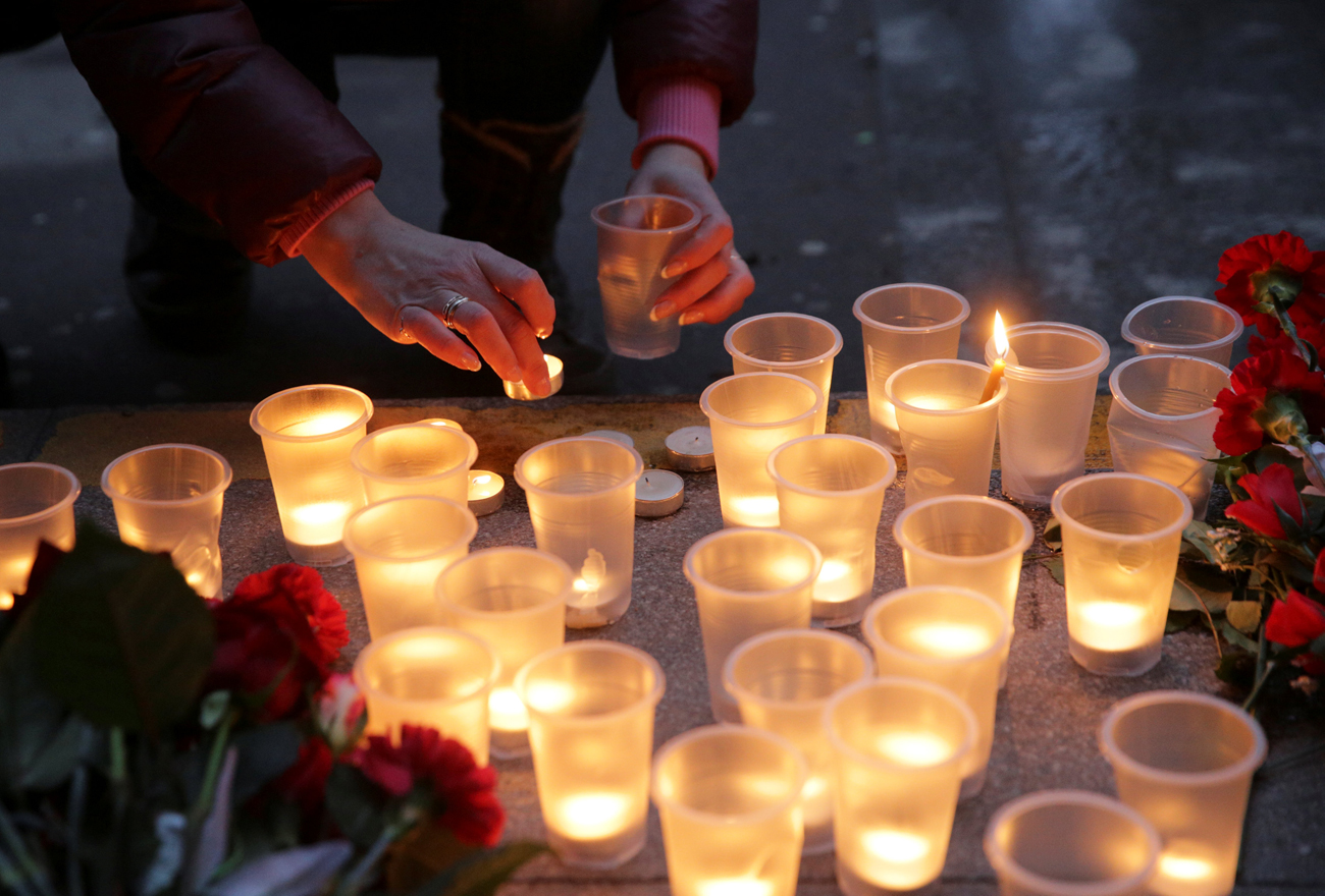 A woman leaves a candle during a memorial service for victims of a blast in St.Petersburg metro, outside Spasskaya metro station in St. Petersburg, April 3, 2017. / Photo: Reuters