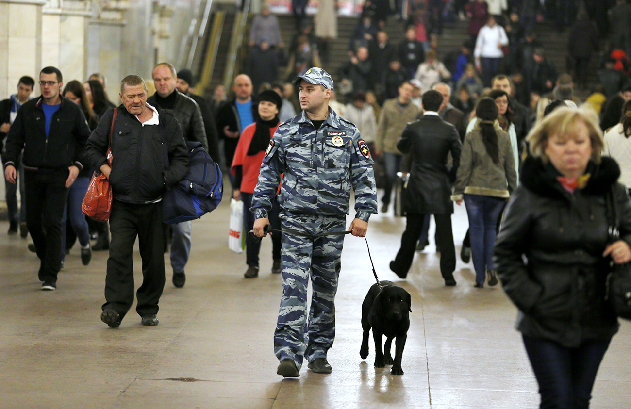 A policeman and his dog are patrolling the Moscow metro. / Photo: Pavel Golovkin/TASS