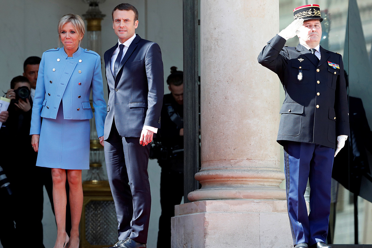 French President Emmanuel Macron and his wife Brigitte Trogneux stand on the steps of the Elysee Palace as former President Francois Hollande (not pictured) leaves after the handover ceremony in Paris, France, May 14, 2017. Source: Reuters