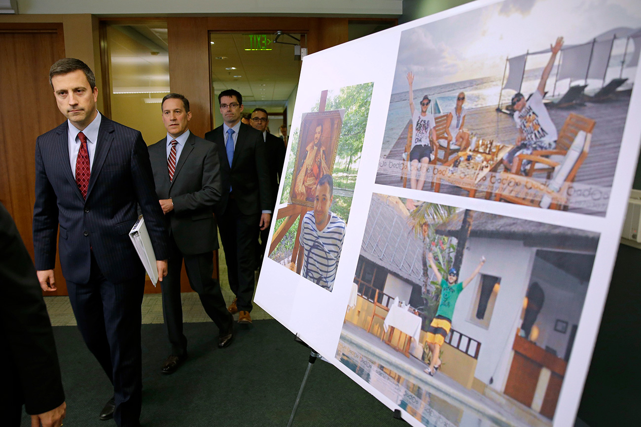 Trevor McFadden, left, acting principal deputy assistant attorney general, and other officials walk past photos of Russian hacker Roman Seleznev as they arrive to talk to reporters on April 21, 2017, following the federal court sentencing of Seleznev to 27 years in prison after he was convicted of hacking into U.S. businesses to steal credit card data. Source: AP