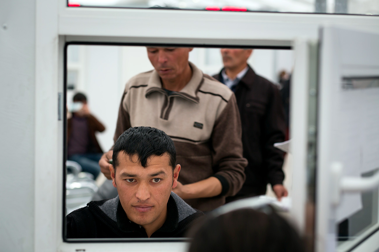 A migrant waits to be interviewed at the Moscow center for registration for migrant workers in Sakharovo village out Moscow. / Photo: AP