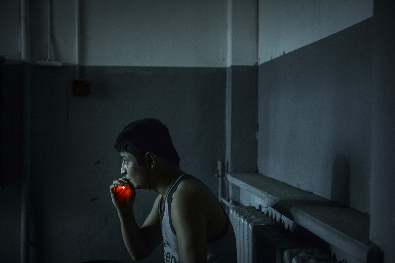 A foreign worker smokes during a raid conducted by the Federal Migration Service to identify illegal migrants in Moscow. / Photo: Valeriy Melnikov/RIA Novosti