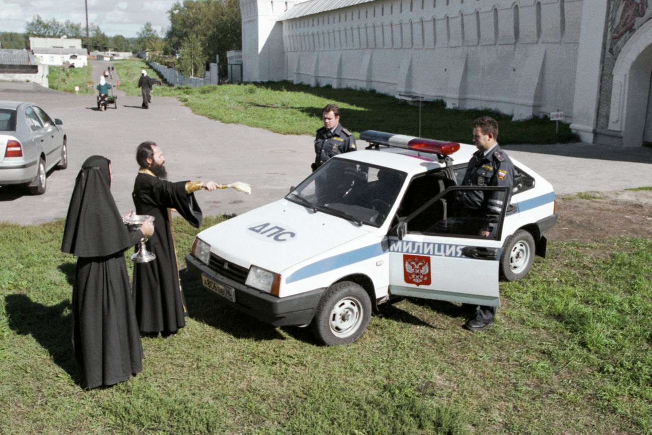 O padre do mosteiro de Tolga, Aleksander, abençoa nova viatura policial na região de Iaroslavl (Foto: Serguei Metelitsa/TASS)