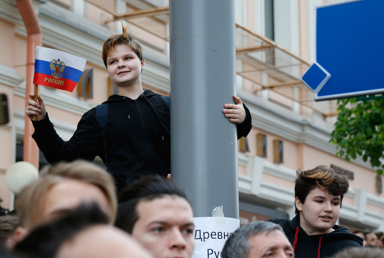 A young protestor holds up a Russian flag during a demonstration in downtown Moscow, June 12, 2017. / AP