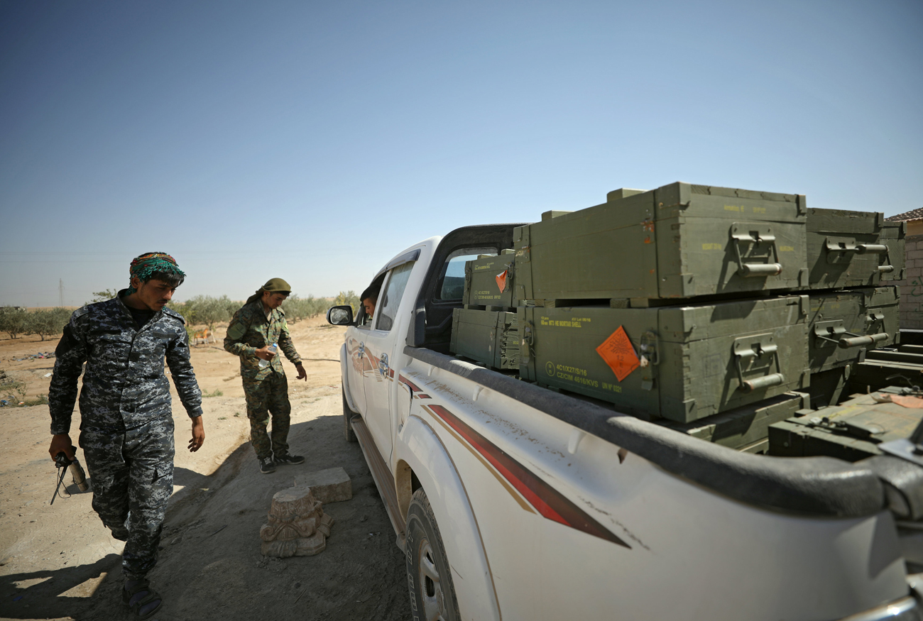 Borci Sirskih demokratičnih sil na vzhodnem obrobju Rake raztovarjajo škatle z orožjem, za katere so dejali, da jih je pripeljala koalicija proti Islamski državi pod vodstvom ZDA. Vir: Reuters