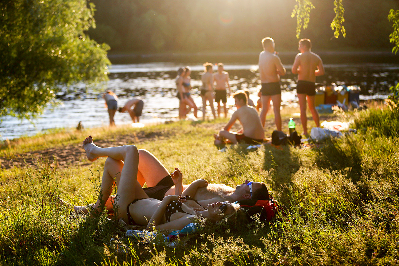 People sunbathing on a beach in Moscow’s Serebryany Bor. Source: Mikhail Pochuyev/TASS