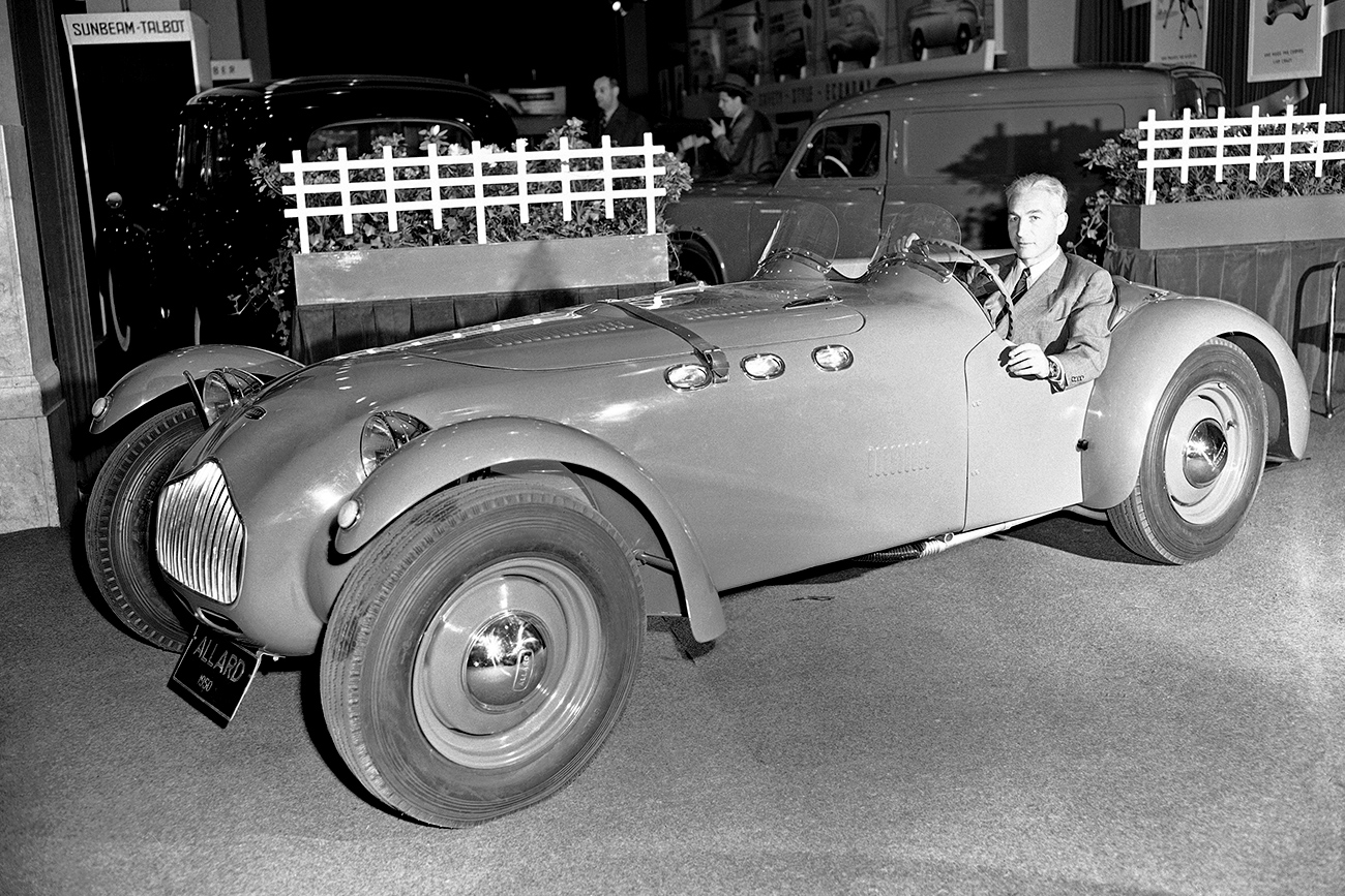 Zora Arkus-Duntov, inventor of the Ardun over head valve conversion kits for Ford V8 Engines, shown at the wheel of an Ardun powered Allard sport roadster which has a speed of over 145-Miles Per-hour. / AP