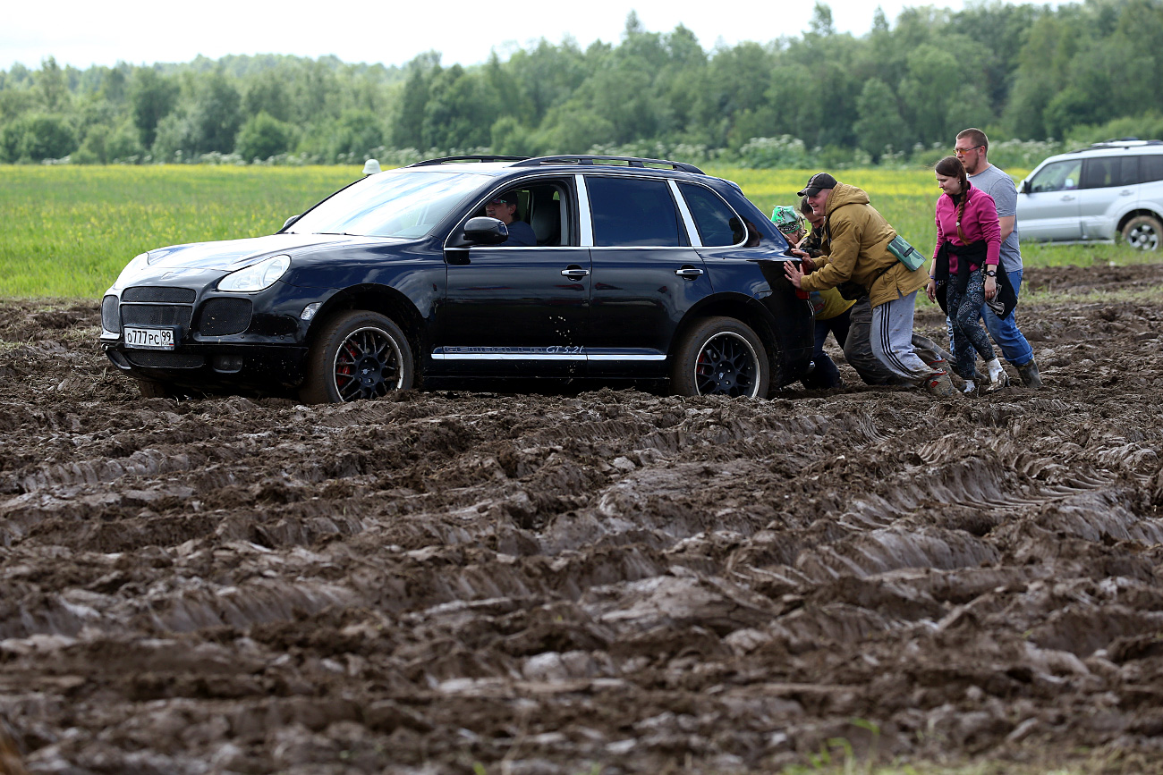Festival-goers pushing a car out of mud at the 2017 Nashestvie music festival.  / Alexander Ryumin/TASS 