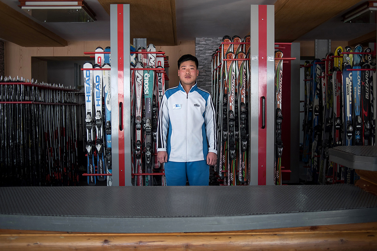 O norte-coreano Kim Chol-Nam, 30, posa para foto no balcão de aluguel de ski de Masikryong, ou Masik Pass, onde trabalha. / AFP