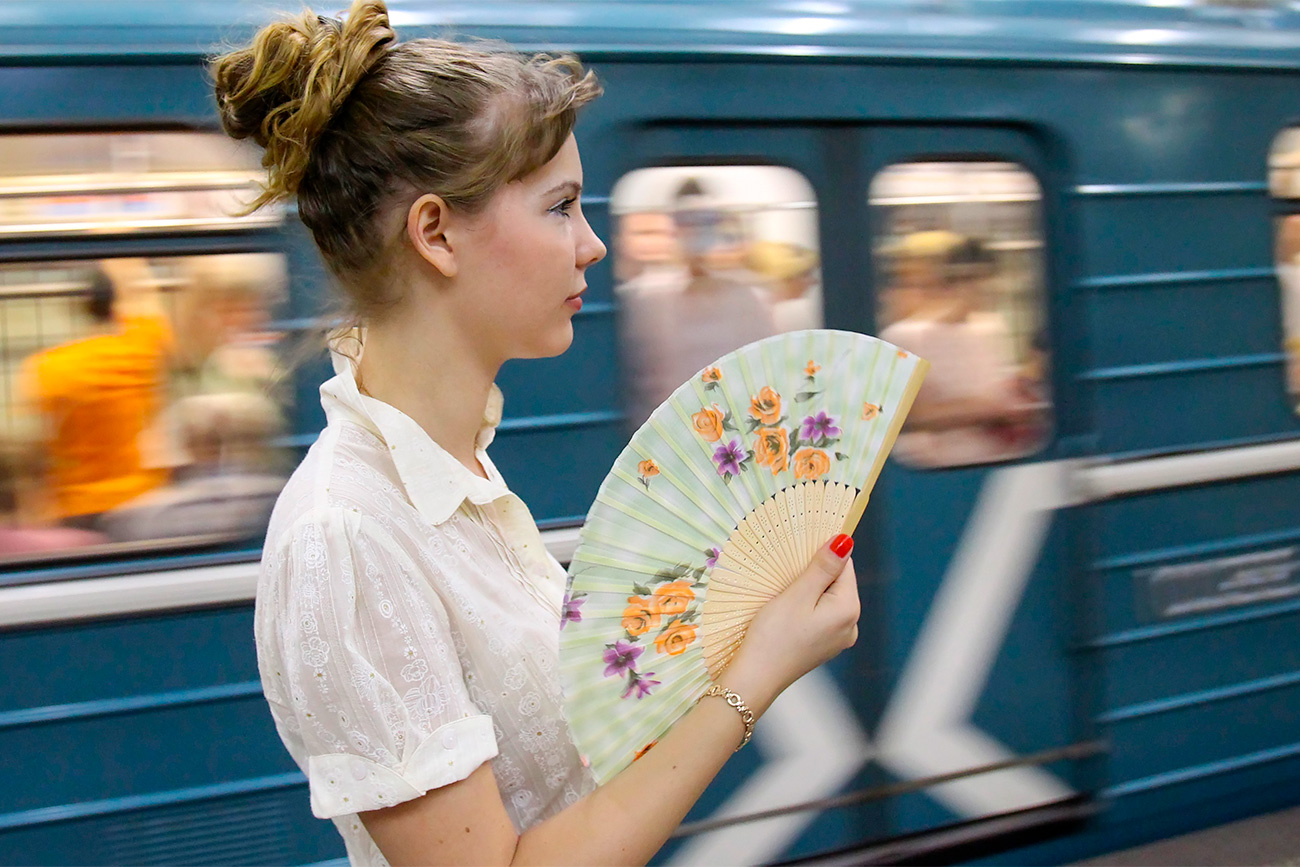 A young woman fanning herself on a platform in the Moscow Metro.  / Vladimir Fedorenko/RIA Novosti
