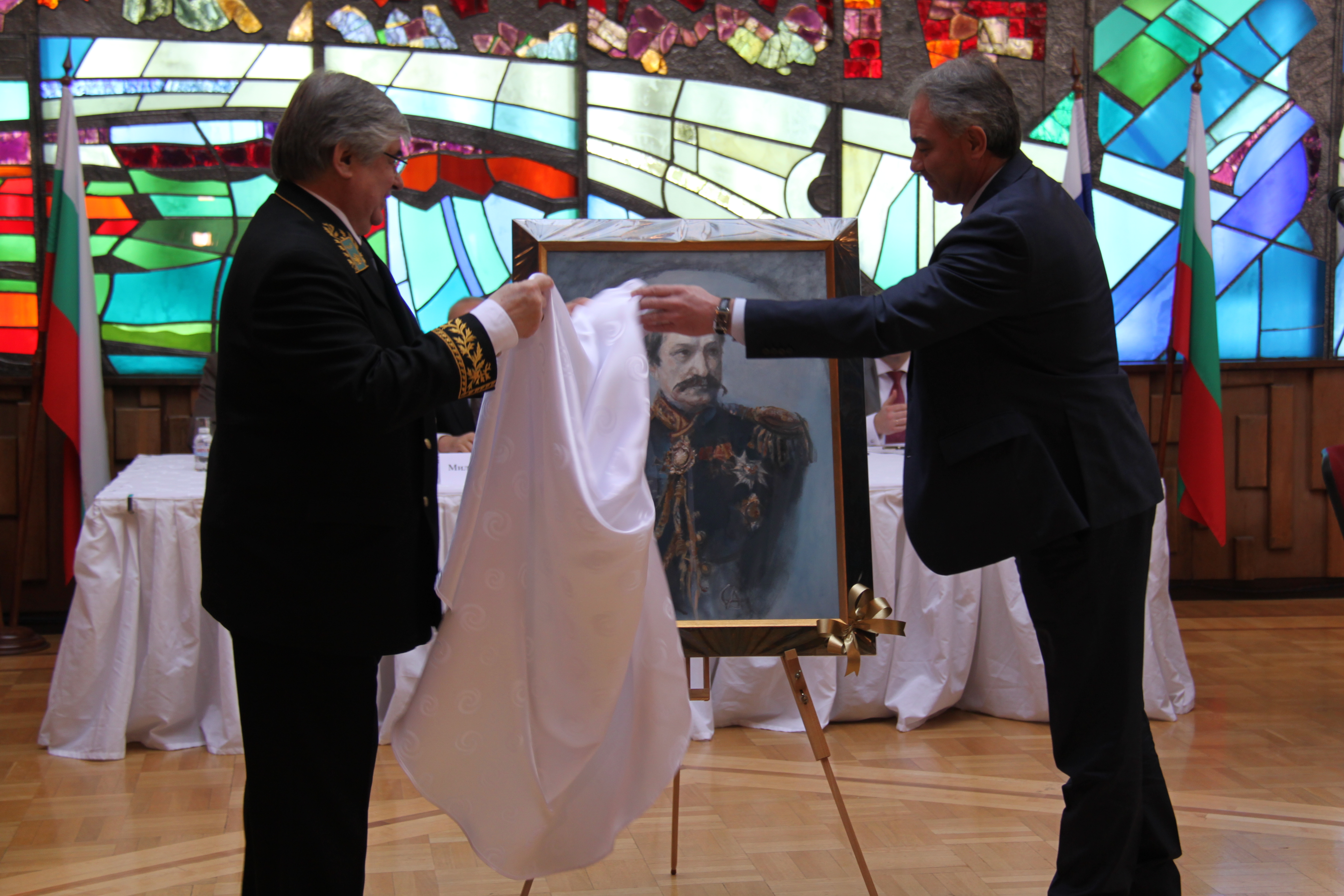 Посланикът на Руската федерация Н. Пр. Анатолий Макаров (в ляво) и лметът на град Плевен Георг Спартански пред портрета на граф Игнатиев.\n