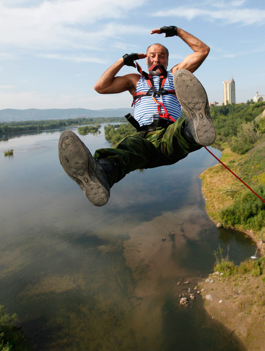 Former Russian paratrooper Alexander Dzhafarov, 53, makes a bungee jump from the October Bridge in Russia's Siberian city of Krasnoyarsk, August 2, 2011. Russians celebrate paratrooper day on Tuesday, a tradition carried over from Soviet times. REUTERS/Ilya Naymushin