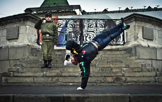 Lagaet, a breakdancer from Portugal, performs a freeze in front of a soldier before the Red Bull BC One breakdancing world finals. Sixteen of the world's best b-boys will compete this Saturday night to determine who is the "one". Source: AP 