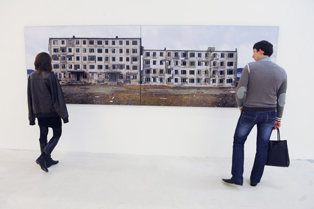 Visitors admire Sergei Shestakov's work from his exhibition "A Trip to the Future. Stop 2. Gudym" during the grand opening of the Photobiennale 2012, held at the Manezh Central Exhibition Hall. Source: RIA Novosti / Iliya Pitalev