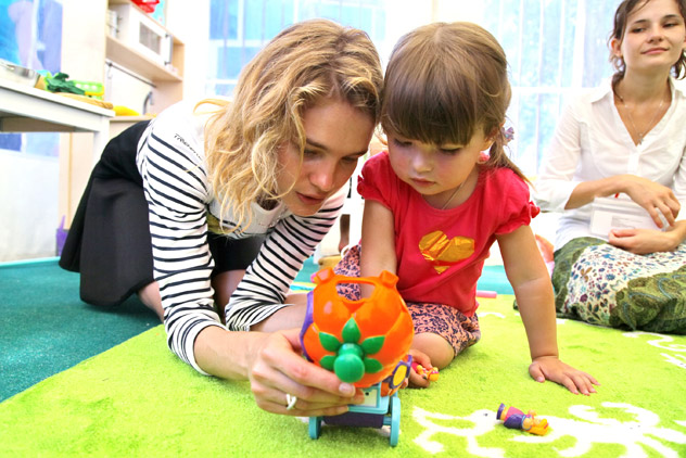 Natalya Vodyanova (left), top fashion model and founder of the Naked Heart Foundation, speaks with a kid at the opening of children's playground in Krymsk during her charitable visit to the town. Source: RIA Novosti / Vera Kostamo